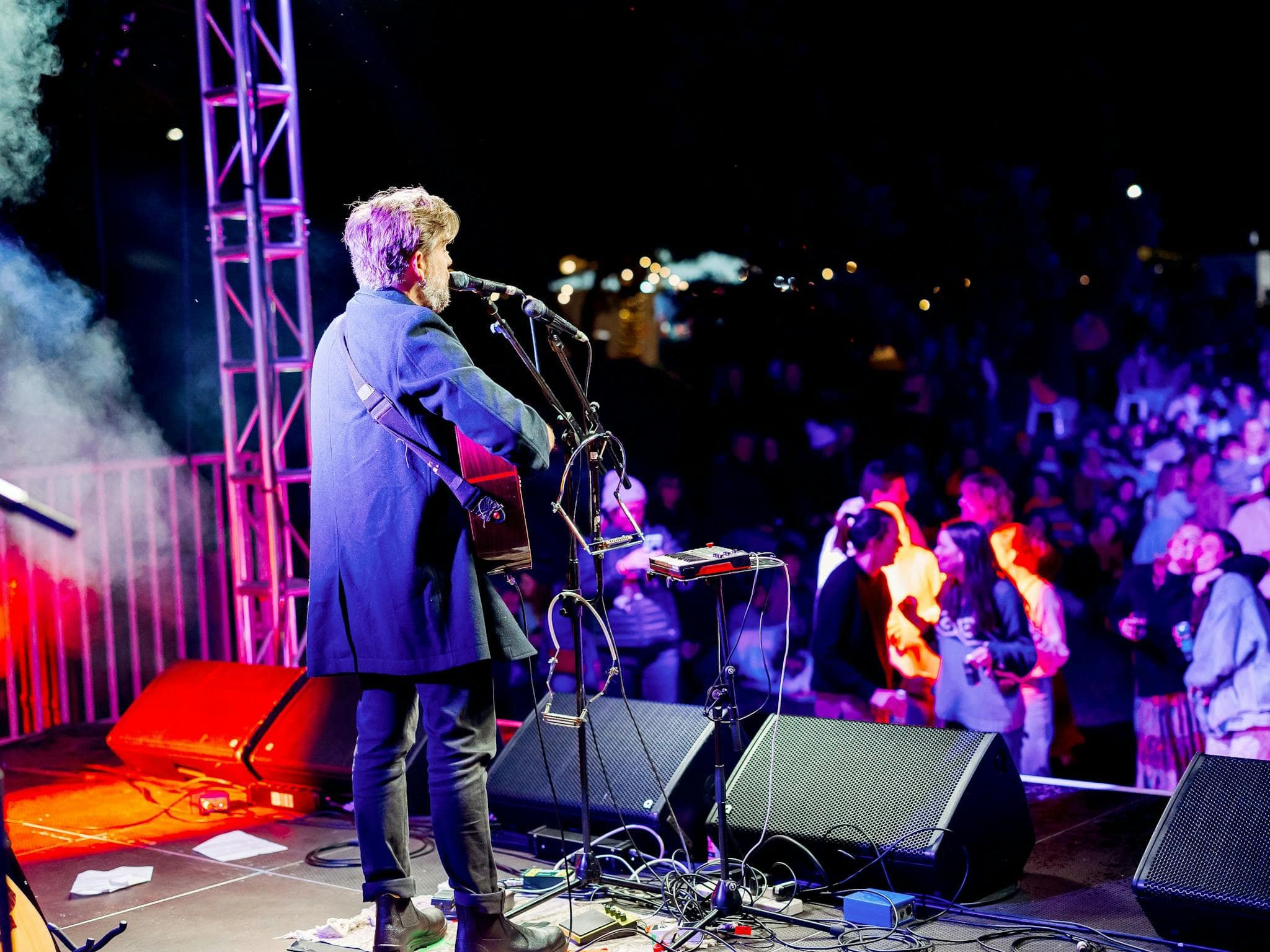 single performer, Josh Pyke plays guitar on a stage in front of a crowd