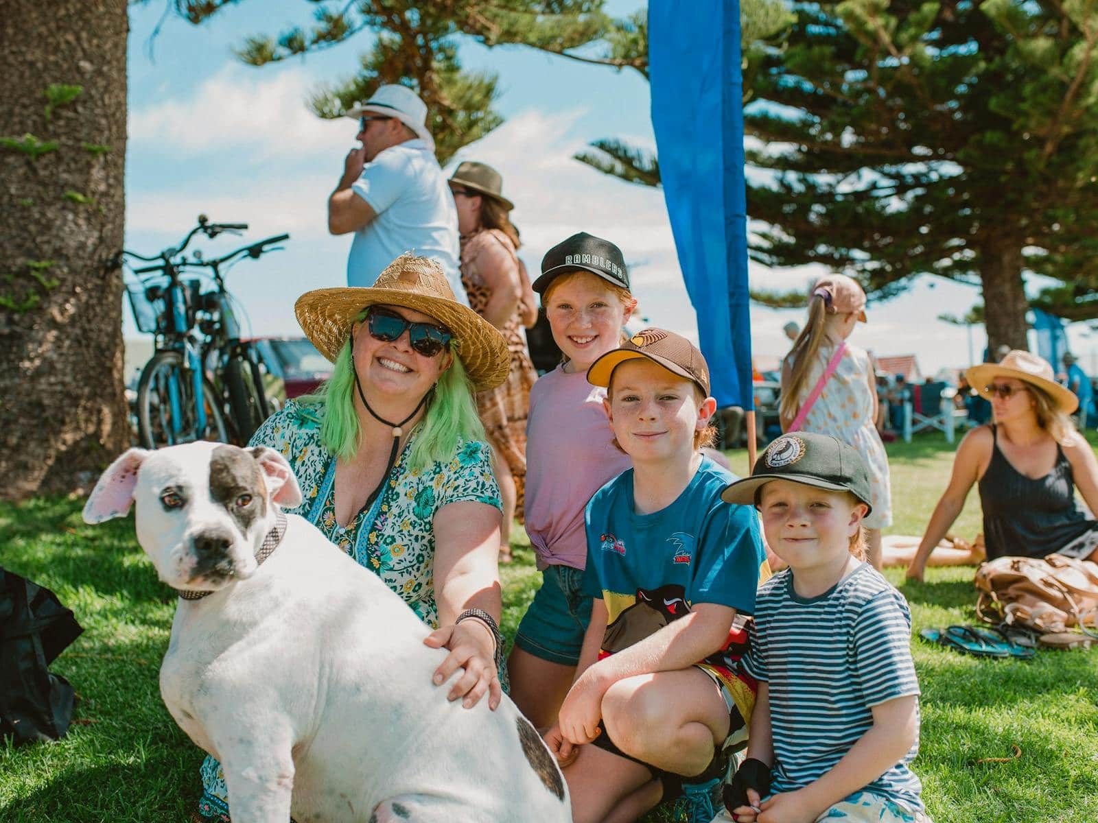 Family with pet dog on the foreshore lawns shaded by the Norfolk-pines.